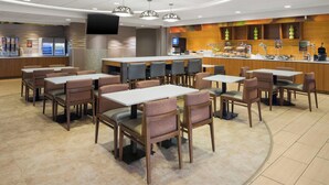 A modern restaurant with multiple seating areas, a bar, and a self-service beverage station.