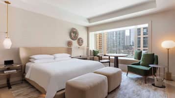 Una camera d'albergo moderna con un letto grande, una scrivania, una sedia e vista sulla città.