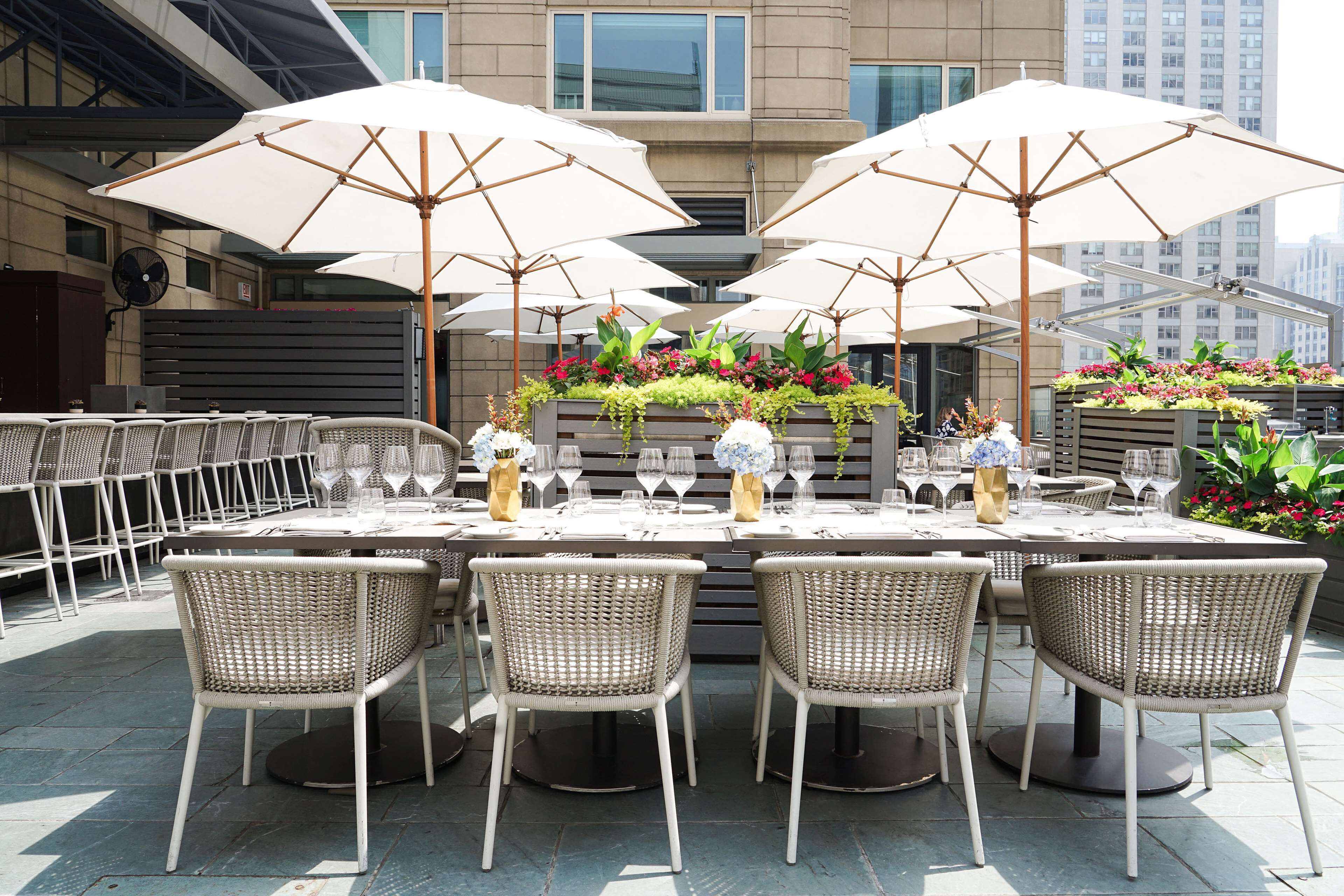 Un espace extérieur aménagé pour les repas, avec des tables, des chaises et des parasols.