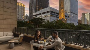 Terraço no telhado com mesa de jantar, cadeiras e vista para a paisagem urbana, incluindo o edifício Water Tower Place.