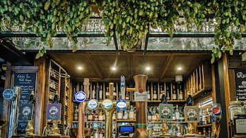 Un bar con varias opciones de grifos y botellas de cerveza, un menú en pizarra y una decoración rústica.