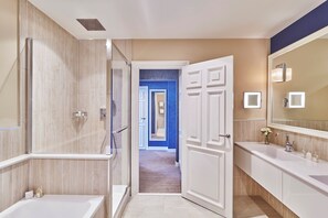 Une salle de bain moderne dotée d’une douche à l’italienne, d’un grand miroir et d’un meuble-lavabo avec un évier et un plan de travail.