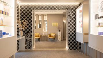 Interior moderno de spa, com área de recepção, assentos e exposição de produtos.