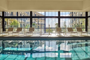 Una piscina techada, sillones reclinables de piscina