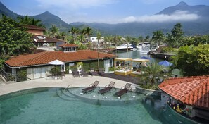 Relax by the serene pool surrounded by lush greenery and majestic mountains.