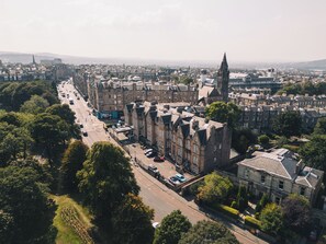An aerial view of a cityscape with historic buildings, a prominent church spire, and a busy street. - JA The Bruntsfield - Edinburgh (Edinburgh)