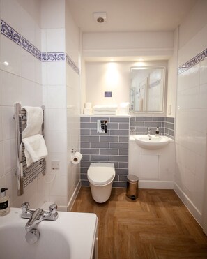 A bathroom with a white bathtub, a white toilet, a sink, and a shower area. - Bruntsfield Hotel, WorldHotels Elite (Edinburgh)