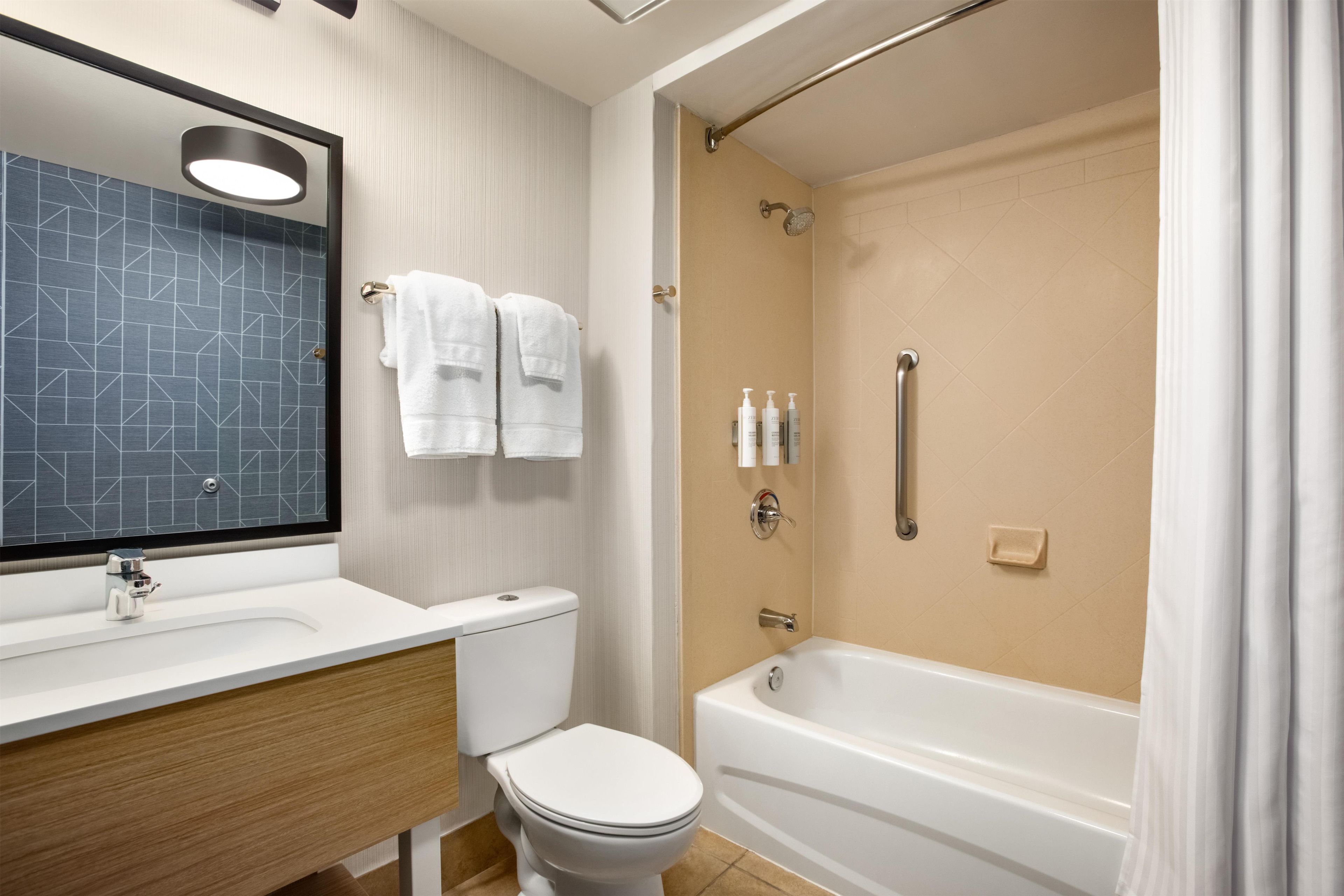 A modern bathroom with a toilet, sink, and bathtub.