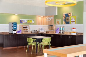 A modern kitchen area with a coffee machine, a toaster, and a display of food items. - Spark by Hilton Columbus East Pickerington (Pickerington)
