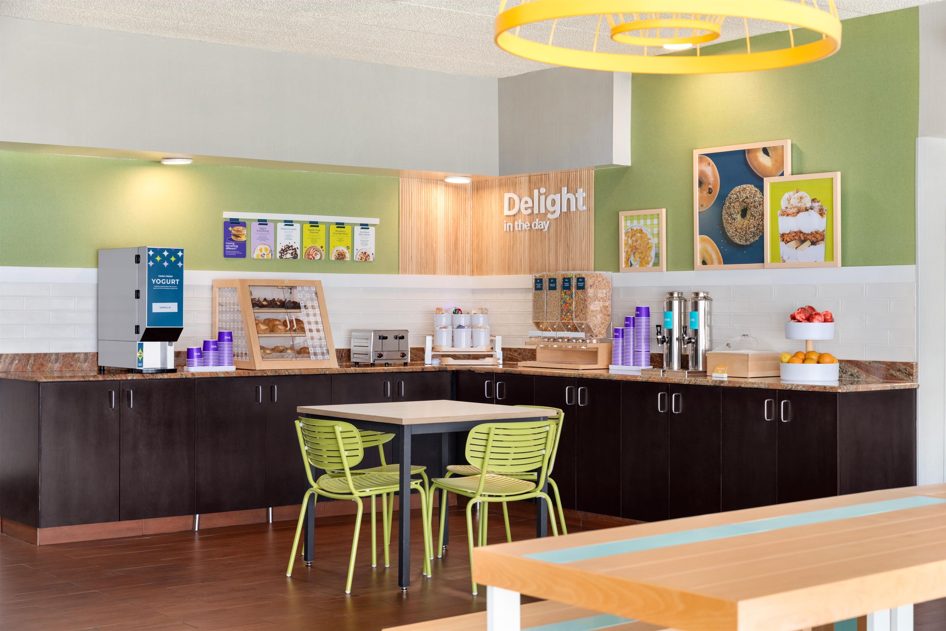 A modern kitchen area with a coffee machine, a toaster, and a display of food items.