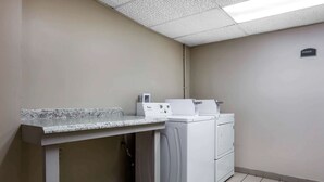 Un espace buanderie comprenant un plan de travail, un lave-linge et un sèche-linge.