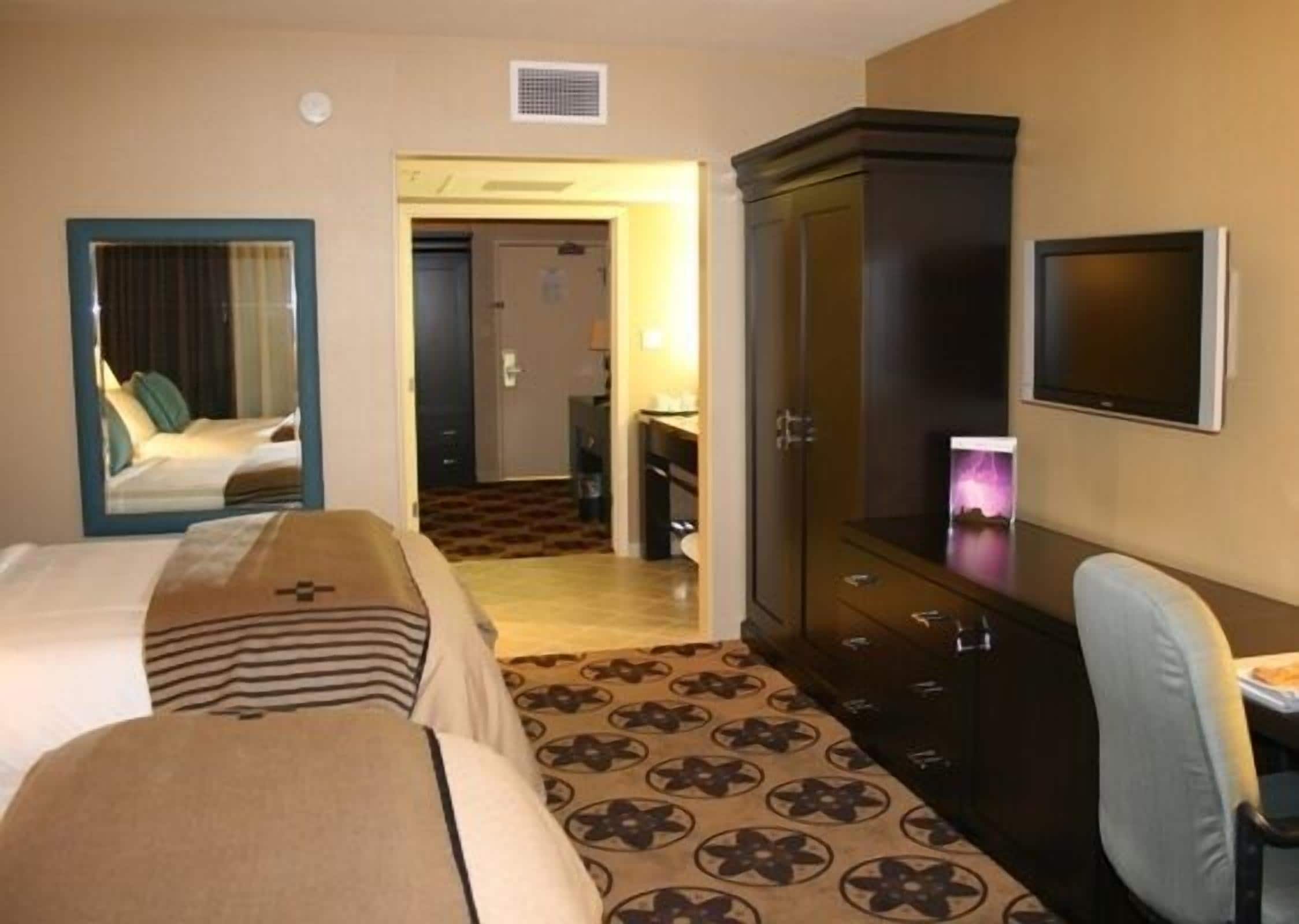 Une chambre d’hôtel équipée d’un lit, d’un bureau, d’une armoire et d’un téléviseur.