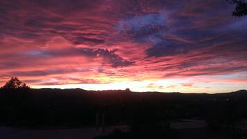 A sunset over a mountainous landscape with a clear sky.