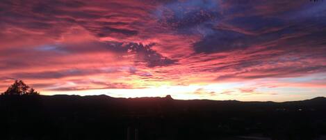 A sunset over a mountainous landscape with a clear sky.