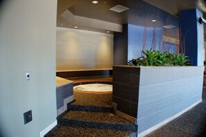 A modern reception area with a reception desk, a seating area, and a decorative plant arrangement.