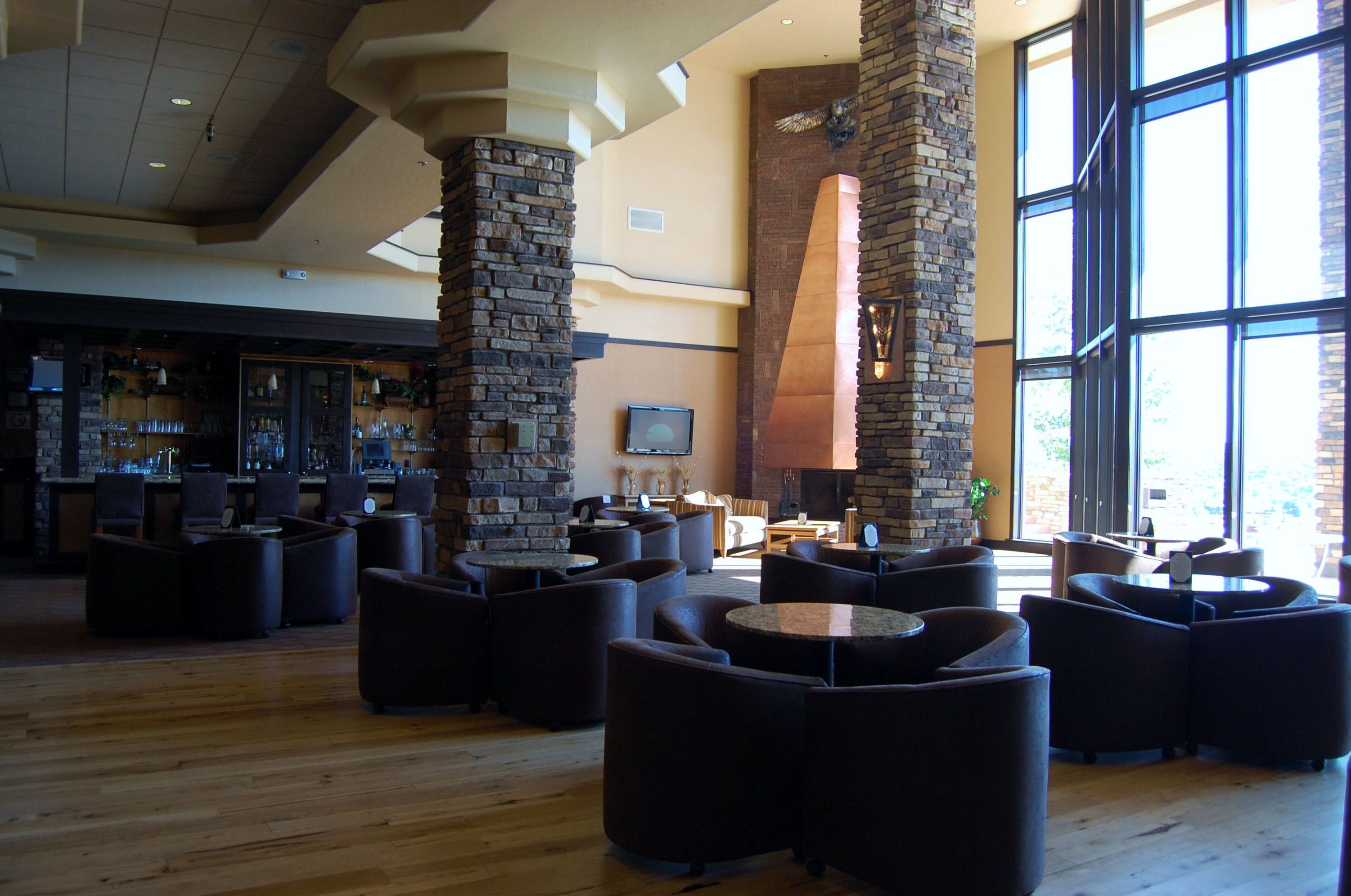 A spacious lobby with a bar area, comfortable seating, and large windows allowing natural light.
