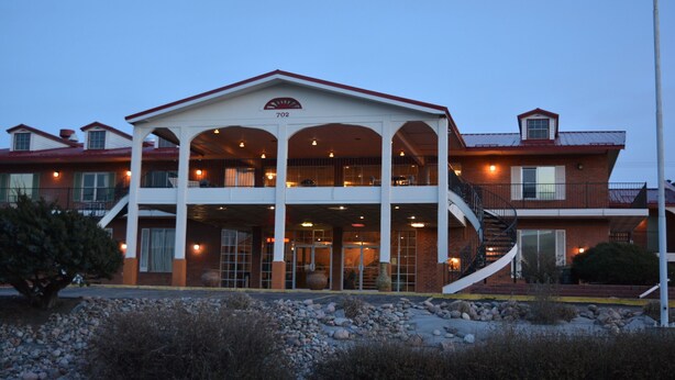 A two-story building with a covered front porch and a staircase leading to the upper level. - Travelodge by Wyndham Trinidad (Trinidad)