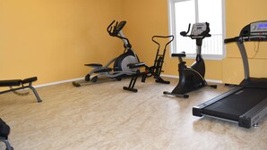 A home gym with a treadmill, elliptical, and stationary bike. - Travelodge by Wyndham Trinidad (Trinidad)