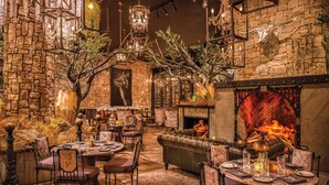 An indoor dining area with stone walls, wooden furniture, and a fireplace. - Caesars Republic Lake Tahoe - A Caesars Rewards Destination (Stateline)