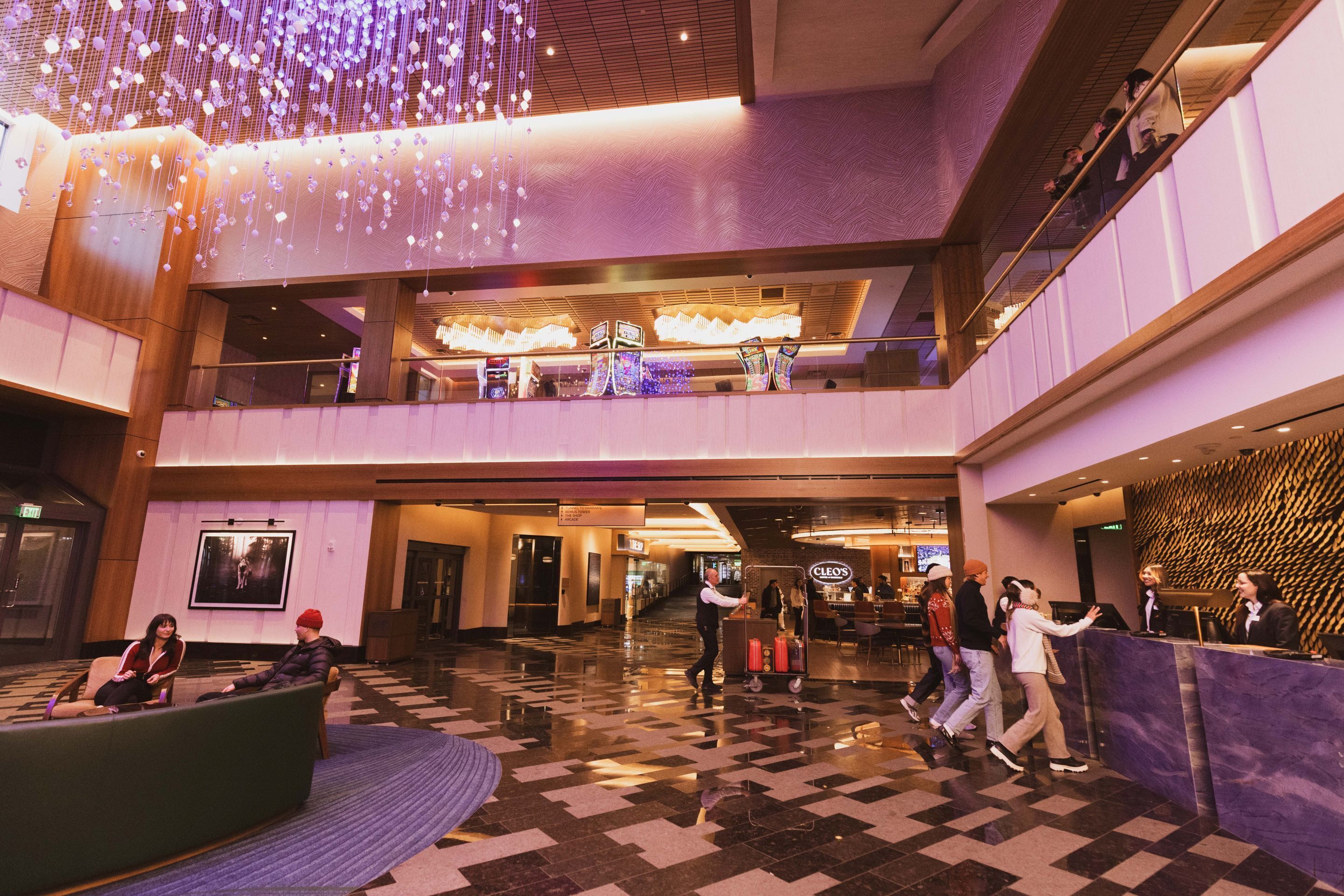 Un vestíbulo de hotel con mostrador de recepción, zona de estar y una escalera.
