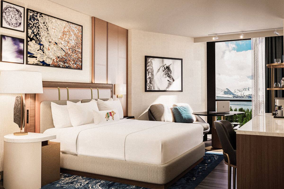Ein modernes Hotelzimmer mit einem großen Bett, einem Schreibtisch und Blick auf eine Berglandschaft.