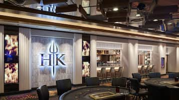 Experience the hotel's upscale lobby, featuring a prominent logo, comfortable seating, and a well-equipped bar.