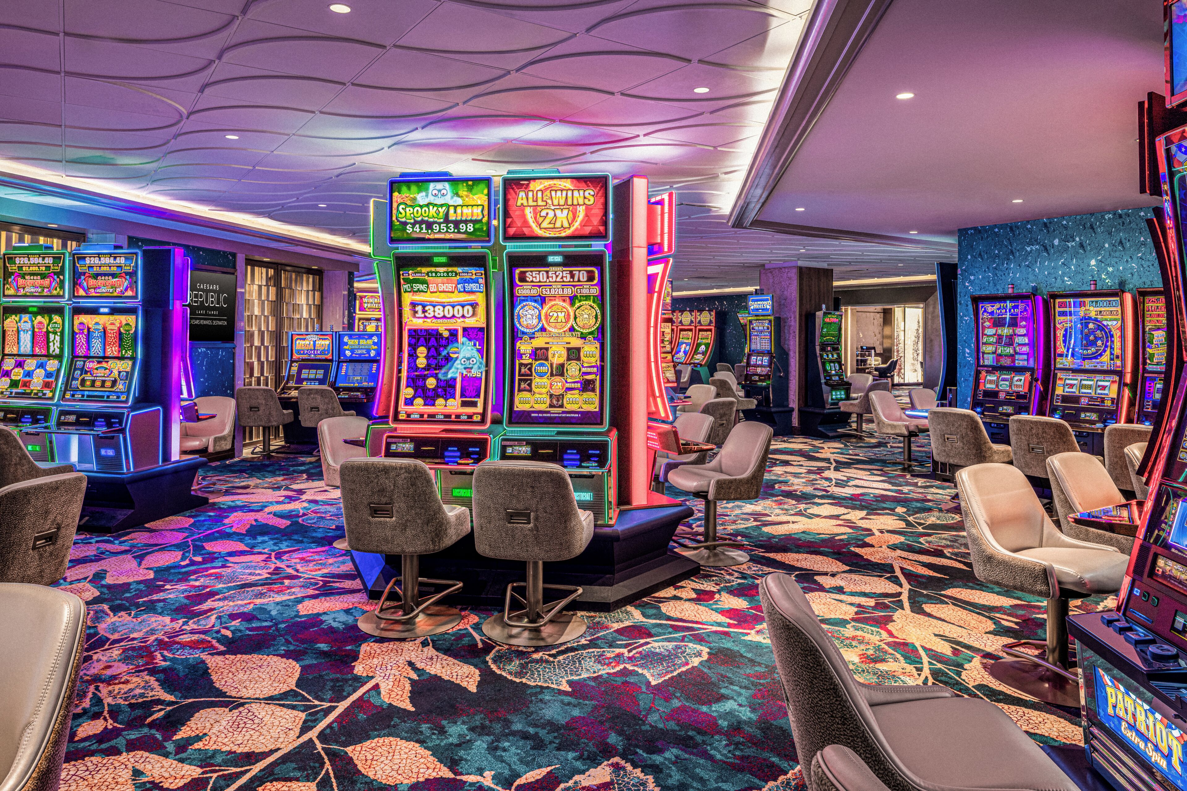 Une salle de casino avec des machines à sous, des tables de jeux et des espaces de détente confortables.