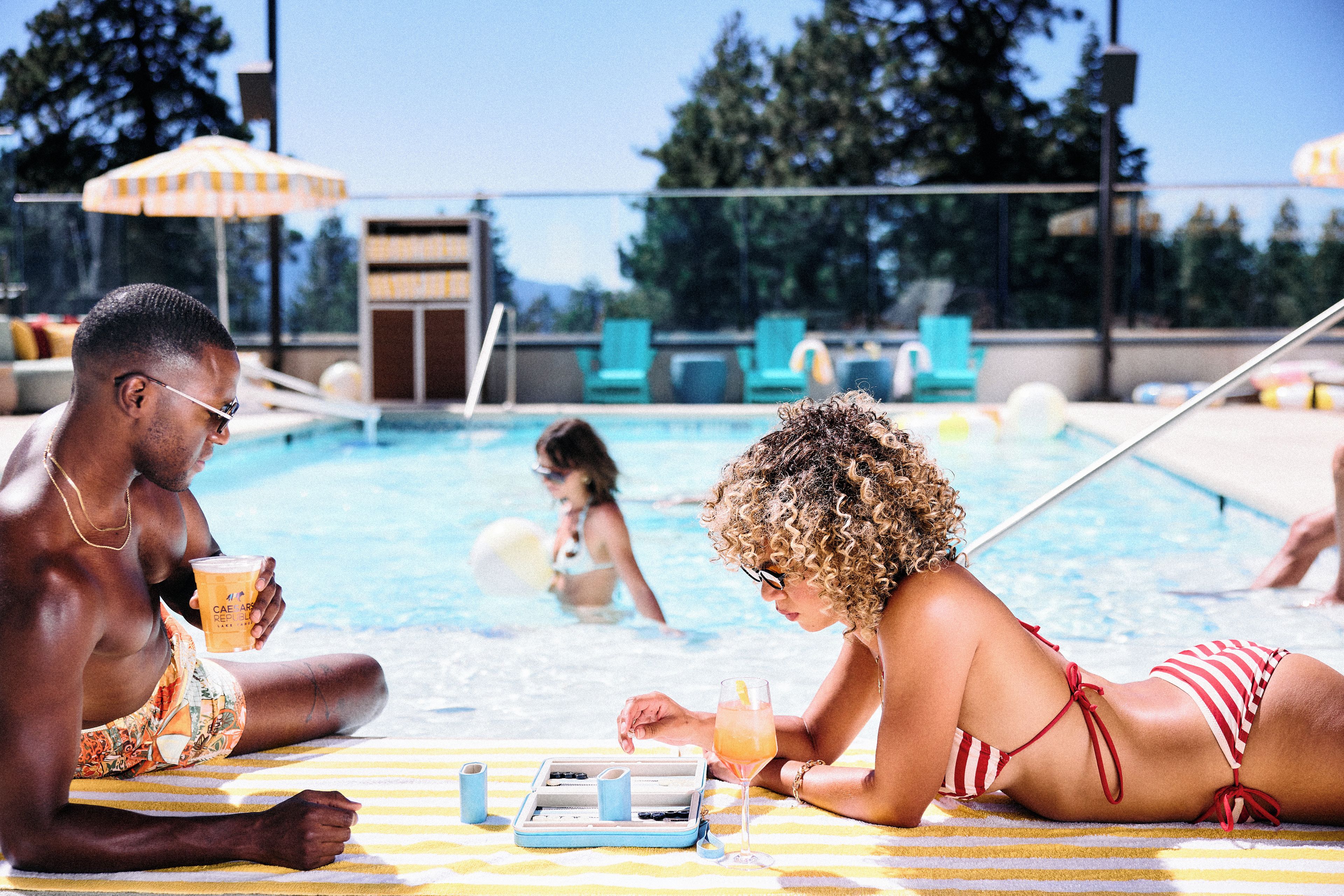 A poolside setting with lounge chairs and a pool.
