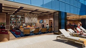 A modern lobby with seating areas, a fireplace, and a bar/lounge area.