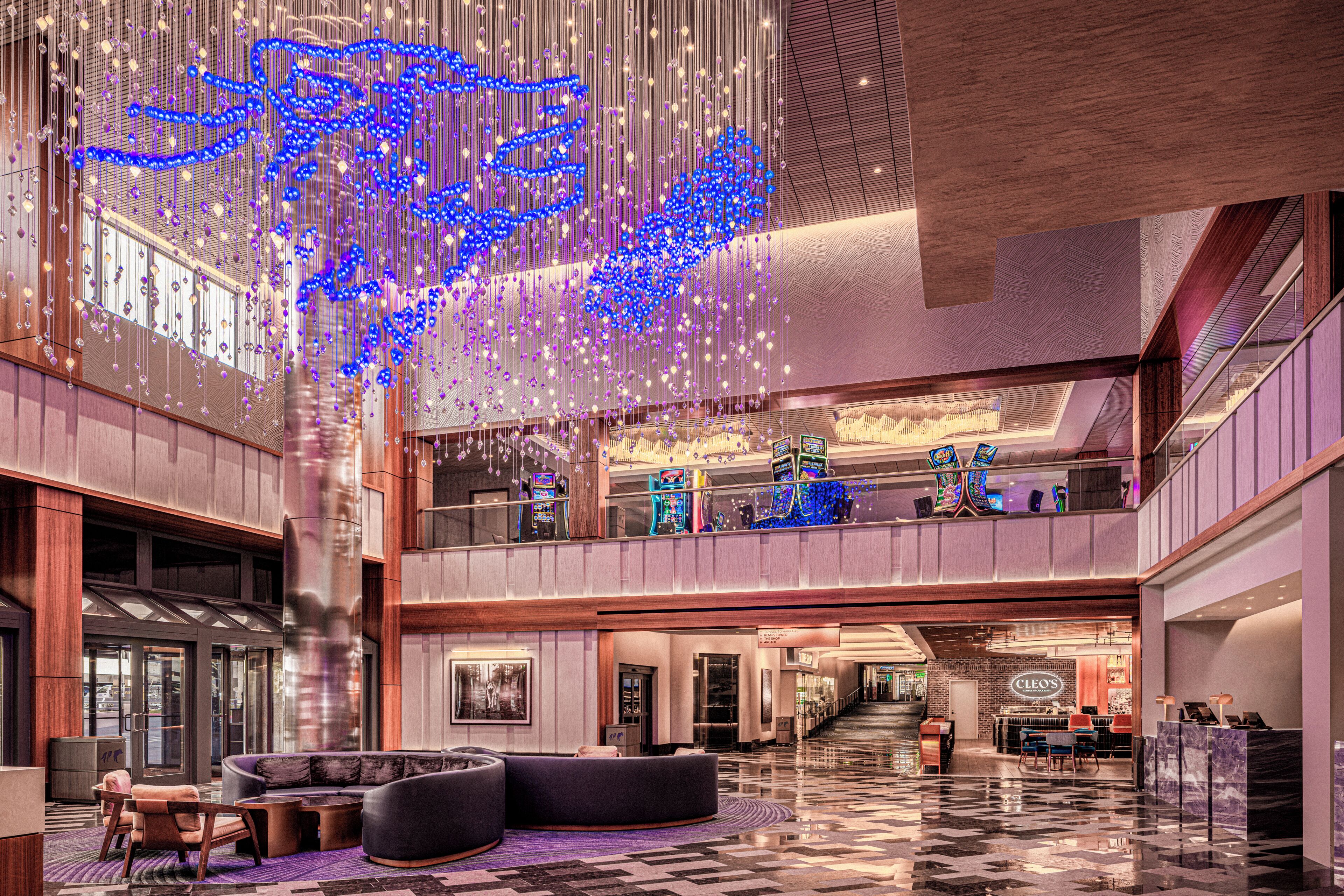 A spacious lobby with a high ceiling, a seating area, and a bar.