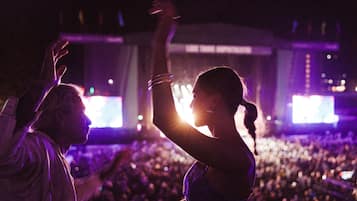 Un concert avec un public nombreux et un jeu de lumière élaboré sur scène.