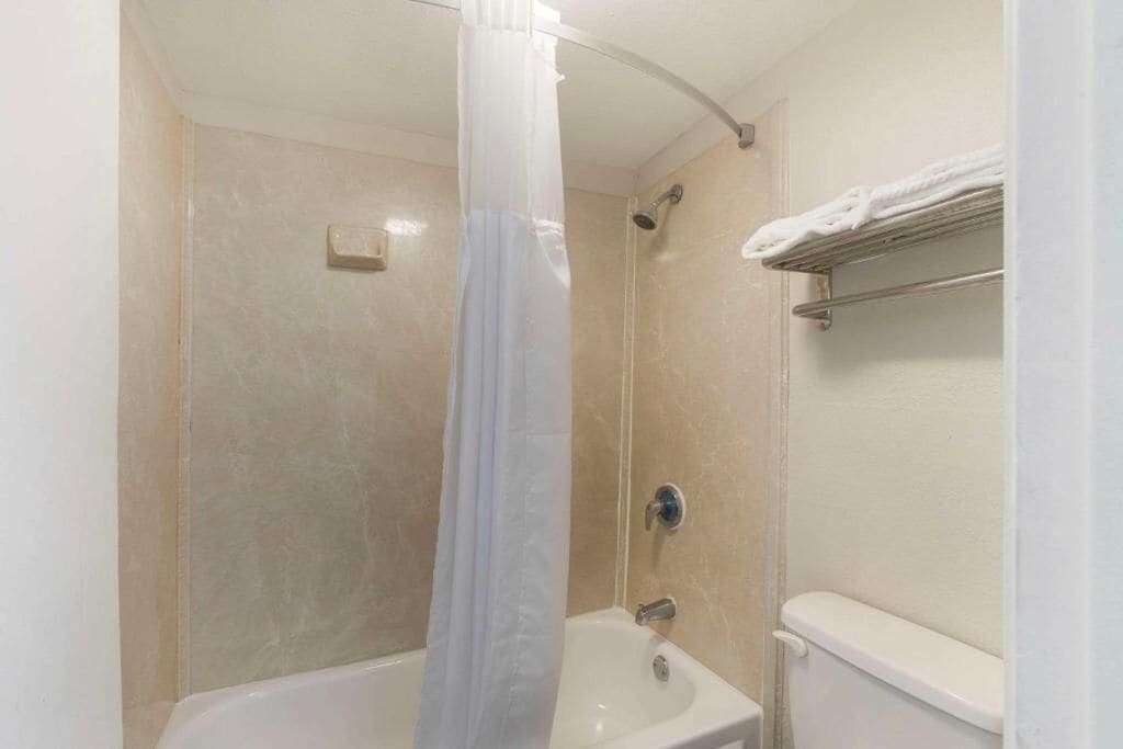 Een badkamer met een douche, een wastafel en een toilet.