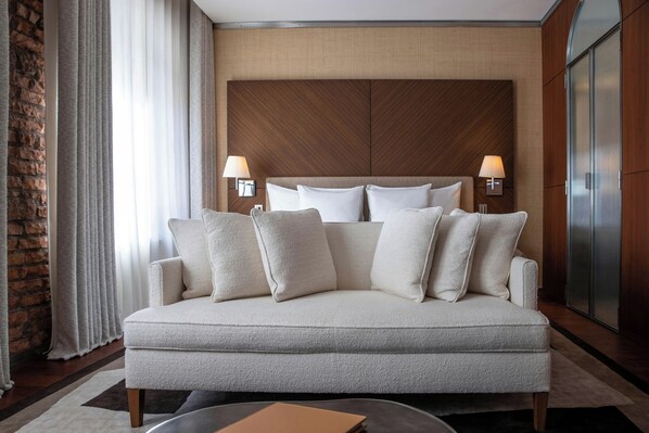 A modern hotel room with a sofa bed, two bedside lamps, and a wooden headboard. - La Réserve Eden au Lac Zurich (Zürich)