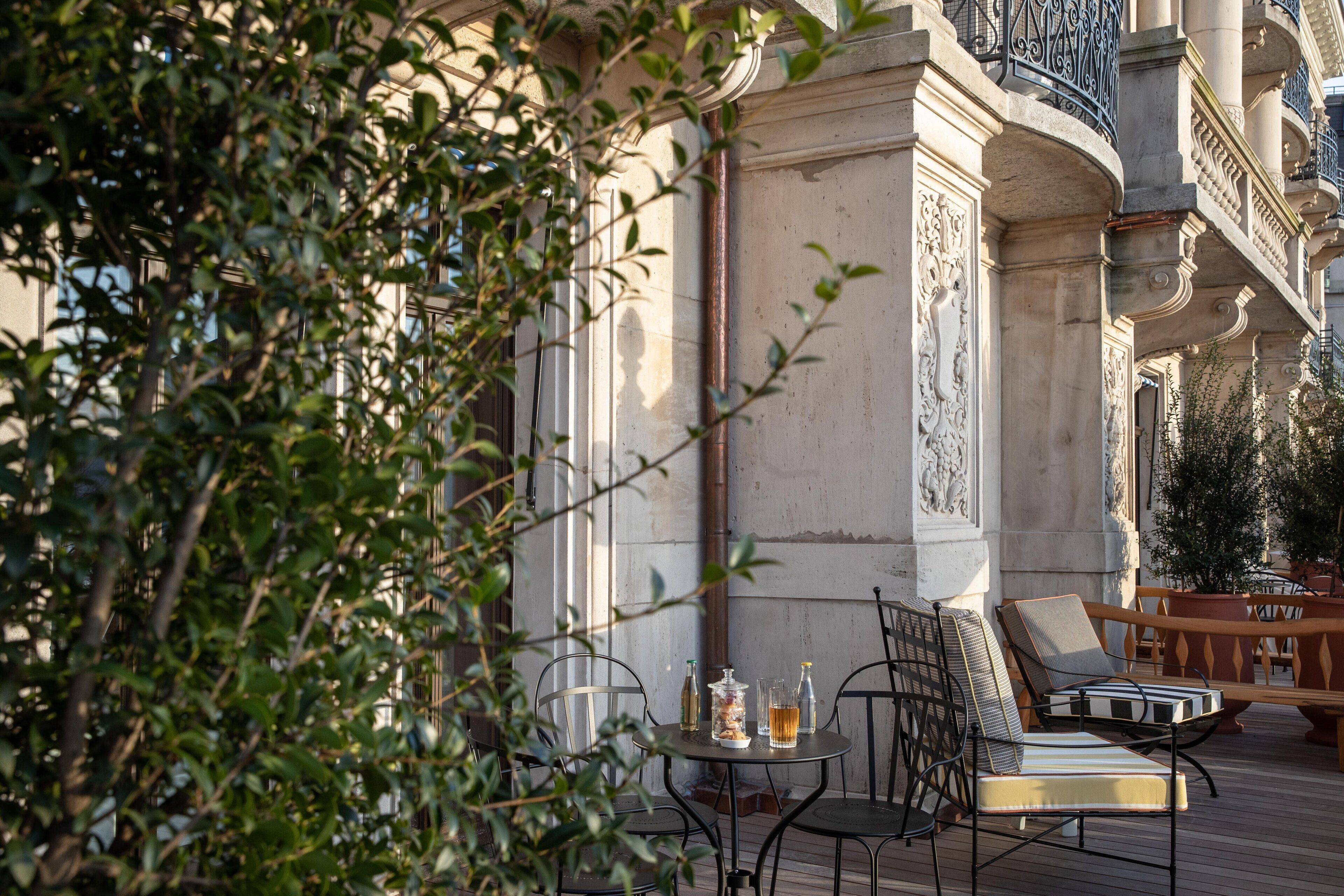 An outdoor seating area with a table, chairs, and a potted plant.