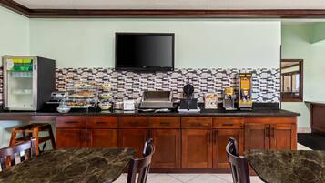 Una cocina equipada con televisión de pantalla plana, cafetera y refrigerador.