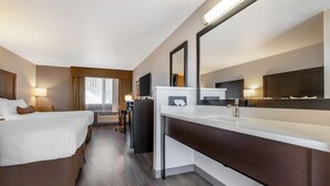 A hotel room with two beds, a desk, a large mirror, and a television. - Best Western Inn Of Vancouver (Vancouver)