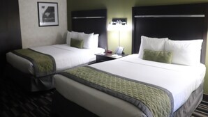 A hotel room with two beds, a nightstand with a lamp, and a framed picture on the wall. - Uptown Oasis San Jose Airport & Silicon Valley (San Jose)