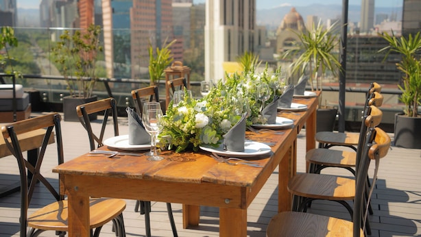 A rooftop dining area with a table set for four, surrounded by chairs, and a cityscape view in the background. - Hotel Fontan Reforma Centro Histórico (Mexico City)