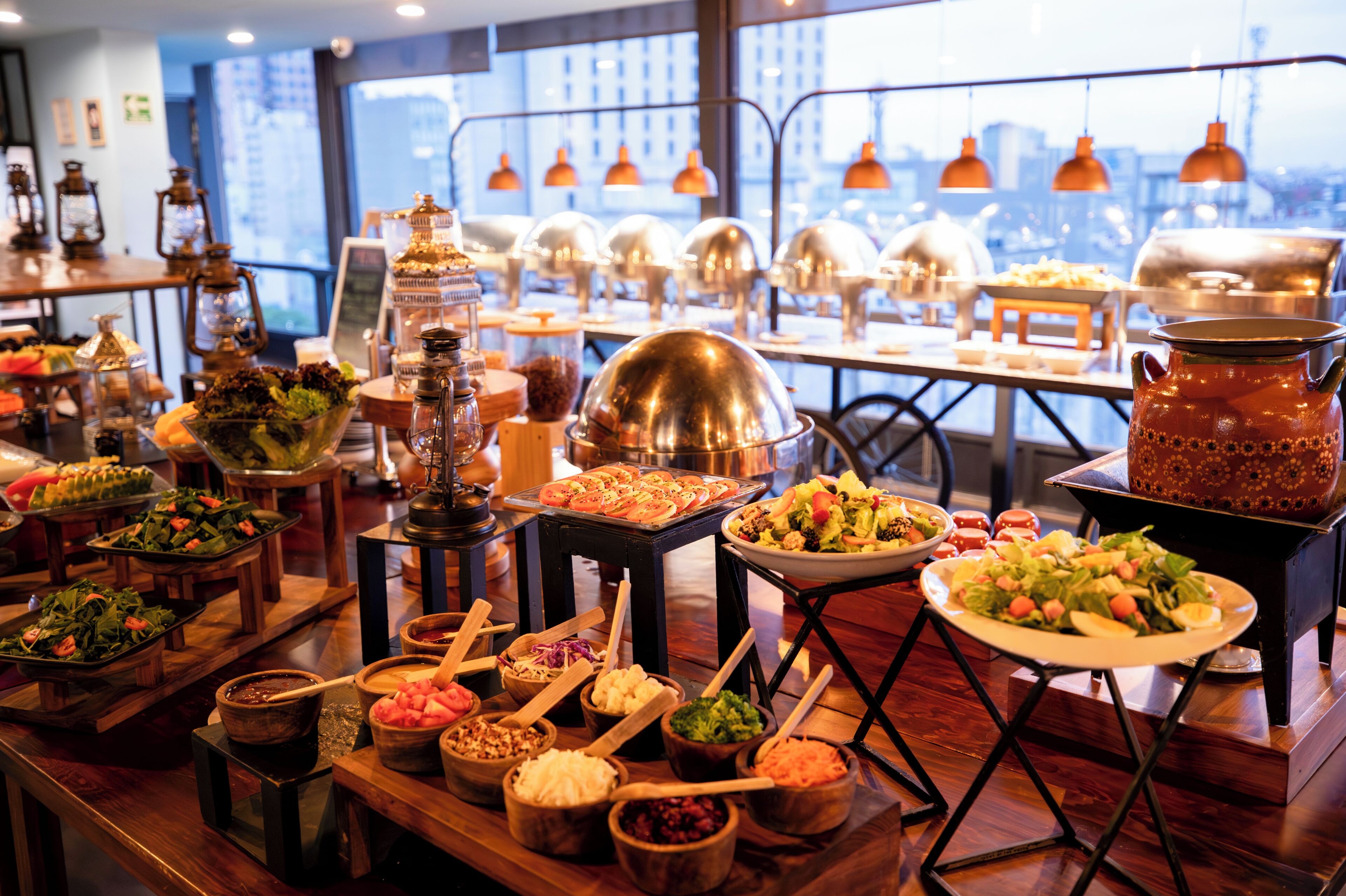 Una mesa de buffet con diversos alimentos y utensilios de servicio.