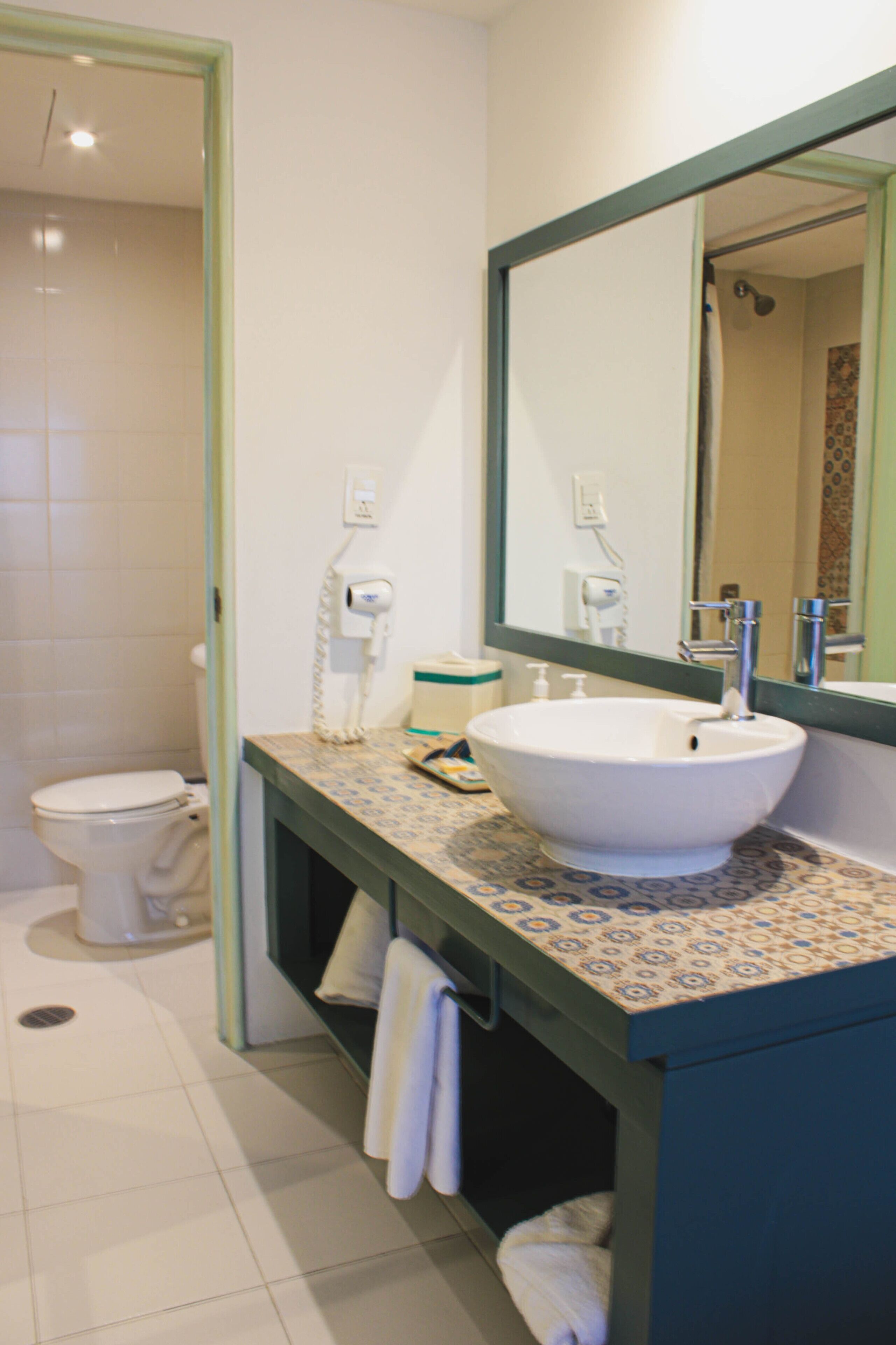 A bathroom with a white sink, a mirror, and a toilet.
