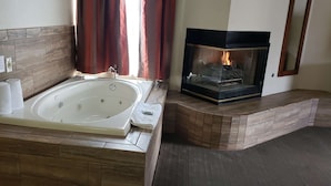 Un baño con una bañera grande, una chimenea y un perchero para toallas.
