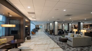 A spacious lobby with a marble floor, seating areas, and a television screen. - Courtyard Miami in Coral Gables by Marriott (Coral Gables)