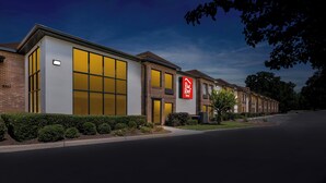 A Red Roof Inn with a modern design, featuring large windows and a brick facade. - Red Roof Inn Charlotte - University (Charlotte)