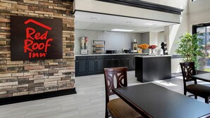 A Red Roof Inn's modern interior with a stone wall, a kitchen area, and a dining space. - Red Roof Inn Charlotte - University (Charlotte)