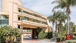 A multi-story hotel with a curved facade, balconies, and a covered entrance. - Econo Lodge Inn & Suites Riverside - Corona (Riverside)