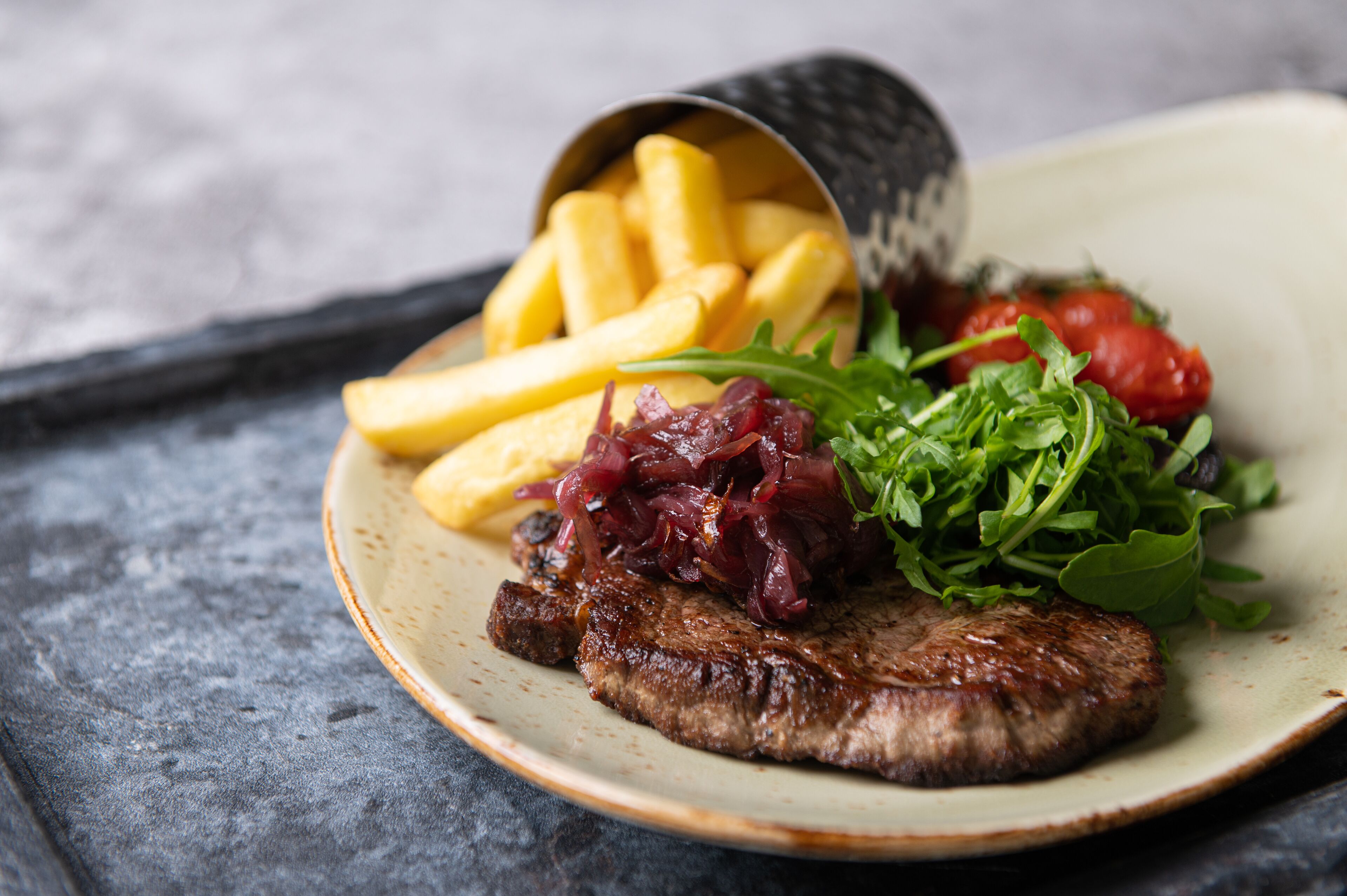 Ein Teller mit einem Steak, Pommes und einem Salat.