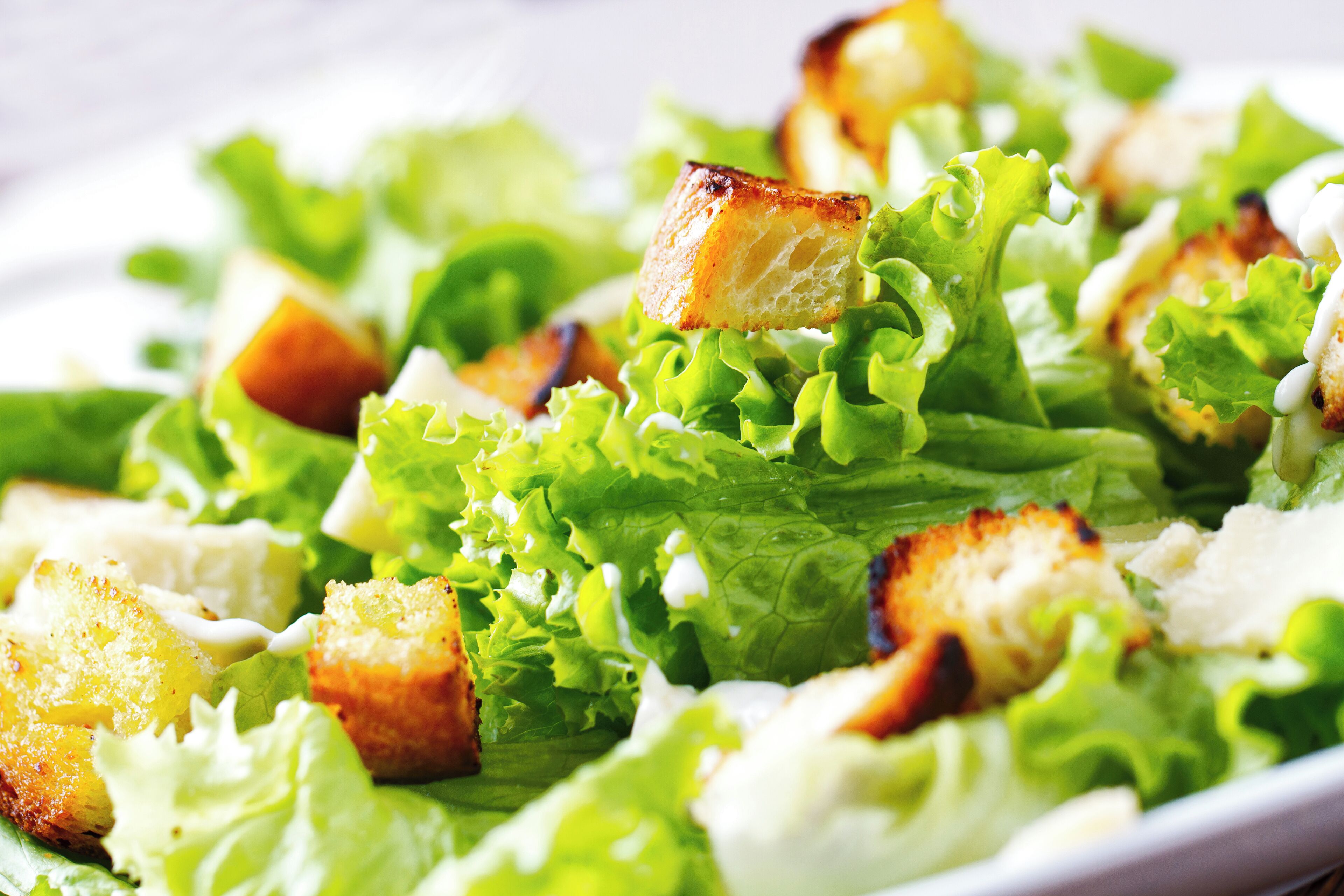 Ein Nahaufnahme von einem Salat mit Croutons und Blattsalat.