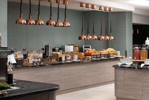 A modern kitchen with copper pendant lights, a marble countertop, and various kitchen appliances and utensils. - Hilton London Gatwick Airport (Gatwick)