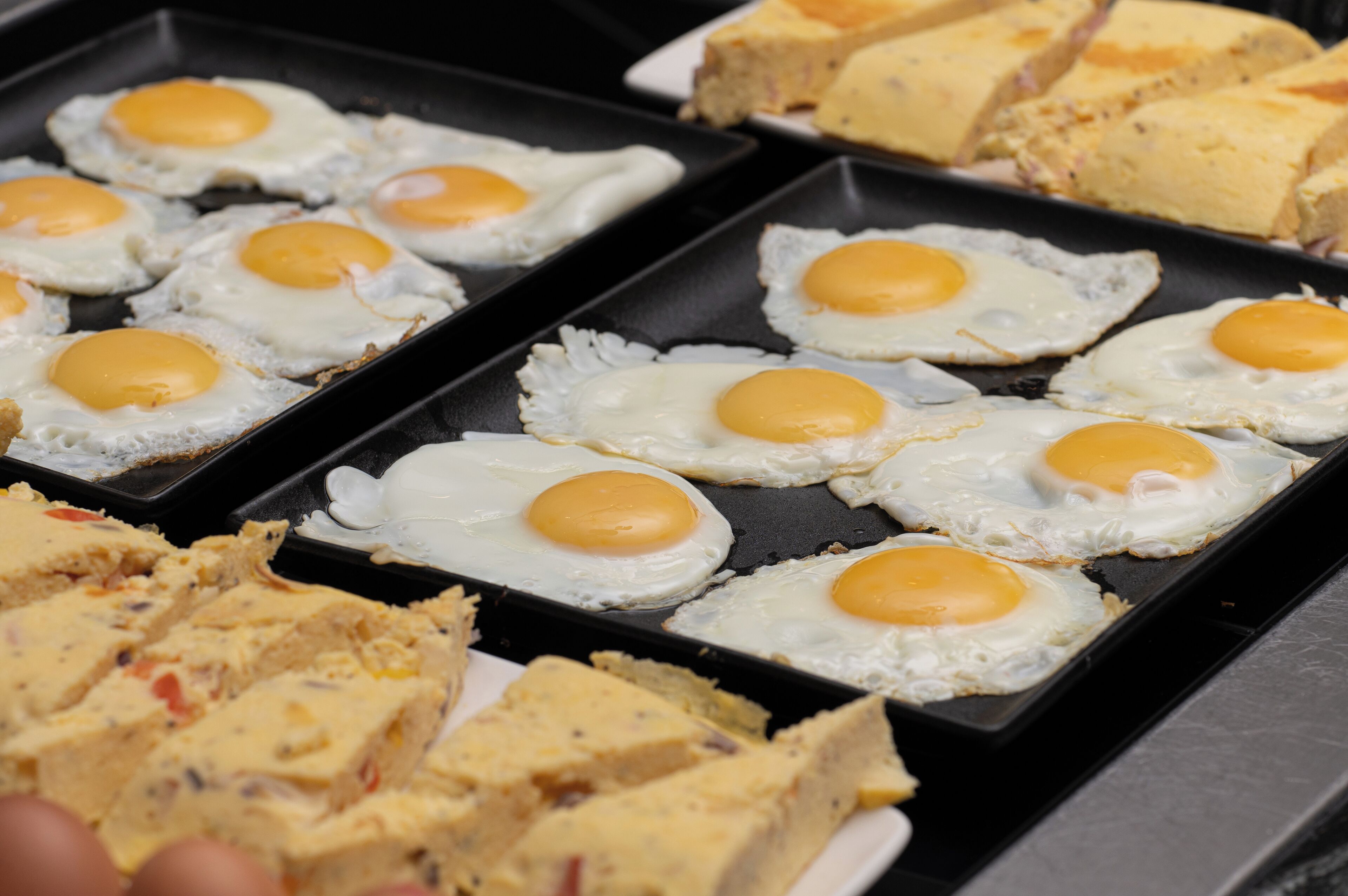 A breakfast tray with fried eggs and a variety of pastries.