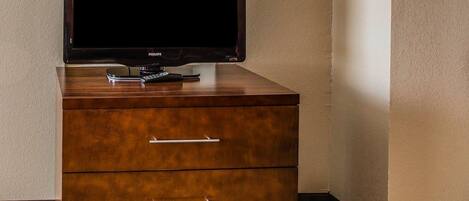 A wooden cabinet with a television on top and three drawers.